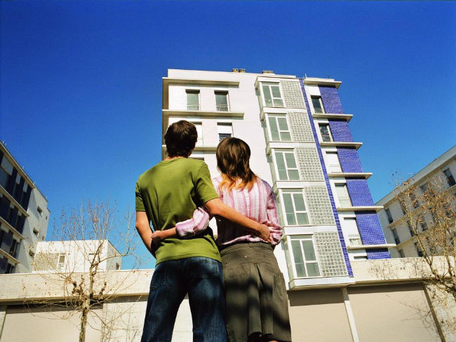 dos joves mirant un edifici d'habitatges